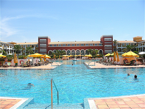 Vista de la piscina con el hotel al fondo