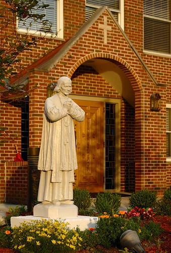 Statue of Saint John Vianney, at Curé of Ars Roman Catholic Church, in Shrewsbury, Missouri, USA - at sunset.