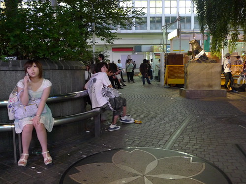 Hachiko statue from afar (and a chick talking on the phone sitting in foreground)