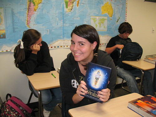 High School Student happily shows her book