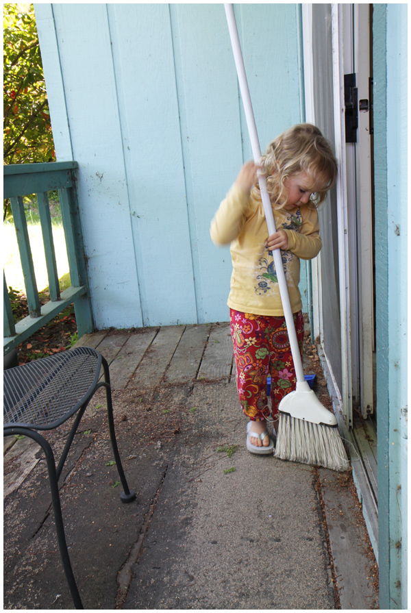 Toddler sweeping the back porch