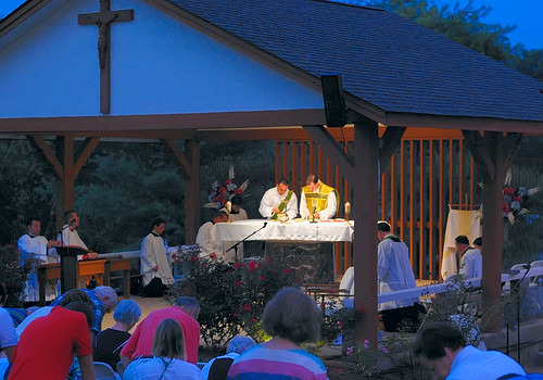 Outdoor novena at the Discalced Carmelite Novena, in Ladue, Missouri, USA - priest and deacon prepare for communion