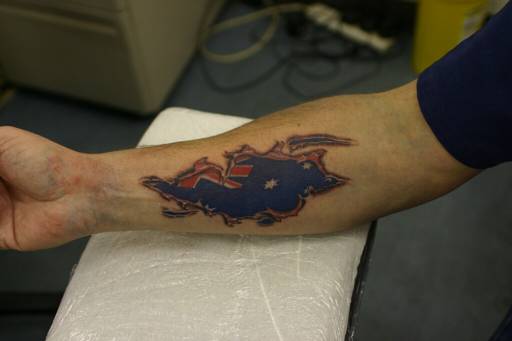 aussi flag skin rip tattoo on forearm