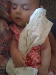 Laila asleep in Salim's arms, holding her burp cloth.