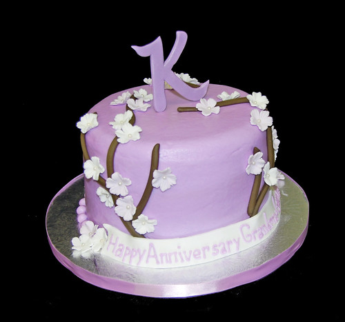 Lavendar Anniversary Cake with branches and flowers topped with a monogram