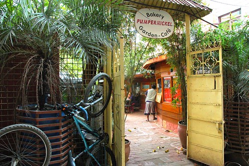 Pumpernickel Bakery Garden - Cafe gate, with bike parked outside, Kathmandu, Nepal by Wonderlane