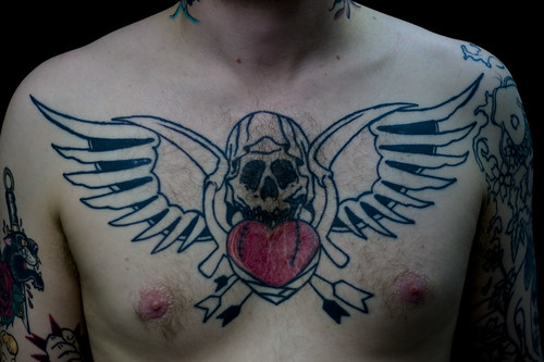 skull with wings chest tattoo