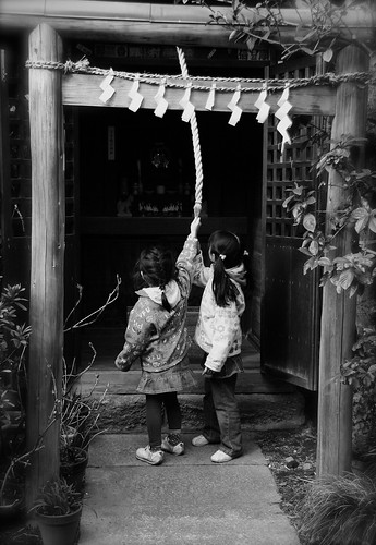Children Ring A Bell At A Shinto Shrine