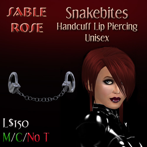 The open handcuff labret piercing has a ruby stud plus a tiny set of silver 