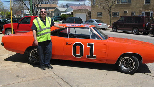 Eddie K posing by the Dukes of Hazzard General Lee TV show car stand