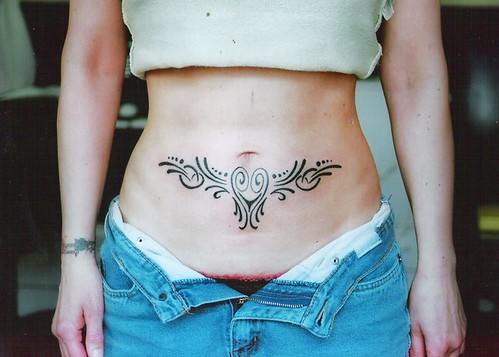 lovely curving black tribal stomach tattoo by tattoodublin.com
