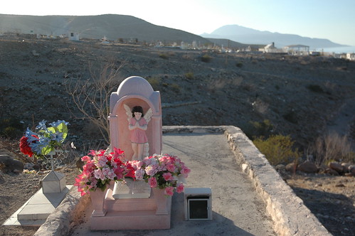 Pink angel with flowers, recently painted grave, desert cemetery, overlooking the Sea of Cortez, San Rosalia, Baja California Sur, Mexico by Wonderlane