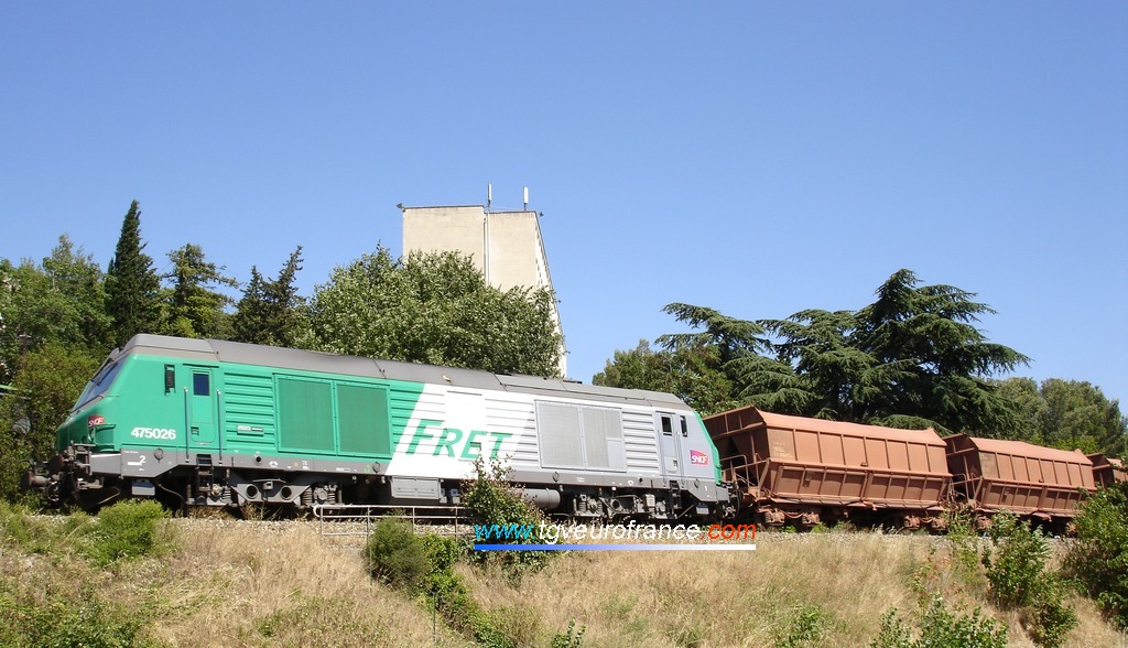 Une locomotive Diesel-électrique BB 475000 en tête d'un convoi de wagons minéraliers de bauxite
