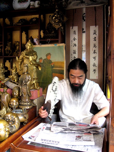 Buddha seller reading a newspaper