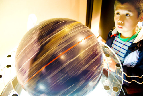 Boy starring at a rotating globe