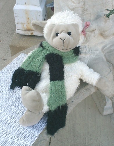 Stuffed sheep modeling a green and black striped handknit scarf