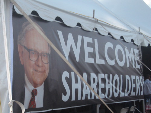 Banner on the side of a tent with an image of Warren Buffet's face that says 