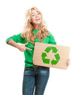 Beautiful and happy young woman holding empty piece of cardboard.