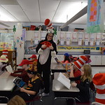 Student in Cat in the Hat costume gives thumbs up while elementary students read
