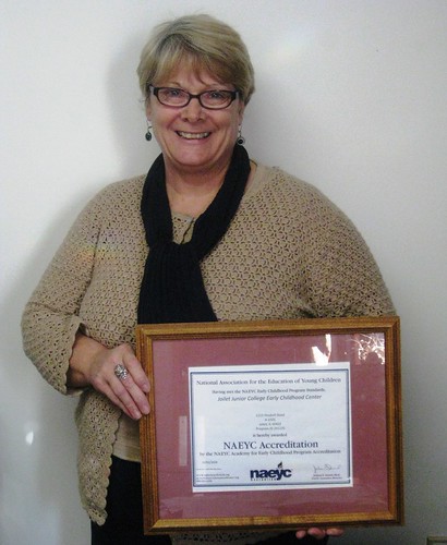 ECC Manager Bev Cavanaugh holds the NAEYC accreditation plaque.