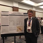 A history major presents his research during a poster presentation.