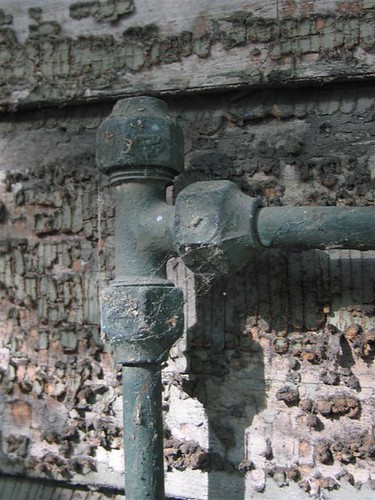 Green copper pipe and rotting paint