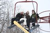 Three snowboarders in a chair lift at Wilmot Mountain, Wisconsin