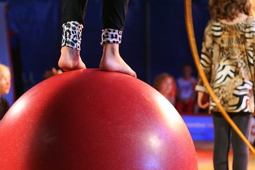 Feet on the big red ball, at the children circus