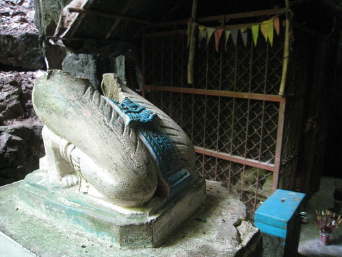 A beheaded Buddha statue in the larger killing cave