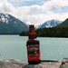 Slightly tilted bottle of Alaskan Amber in front of Kenai Lake