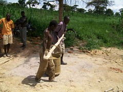 Men haul a bucket full of mud