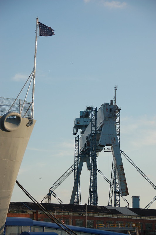 USS Salem: Ships bow flag & nearby General Dynamics shipyard crane "Goliath"<br/>© <a href="https://flickr.com/people/9161595@N03" target="_blank" rel="nofollow">9161595@N03</a> (<a href="https://flickr.com/photo.gne?id=2795337064" target="_blank" rel="nofollow">Flickr</a>)