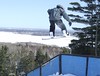 A snowboarder jumps above a rail in the terrain park at Spirit Mountain, Minnesota