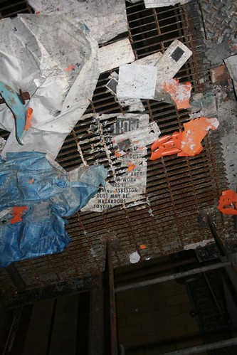 Destroyed asbestos warning sign on catwalk