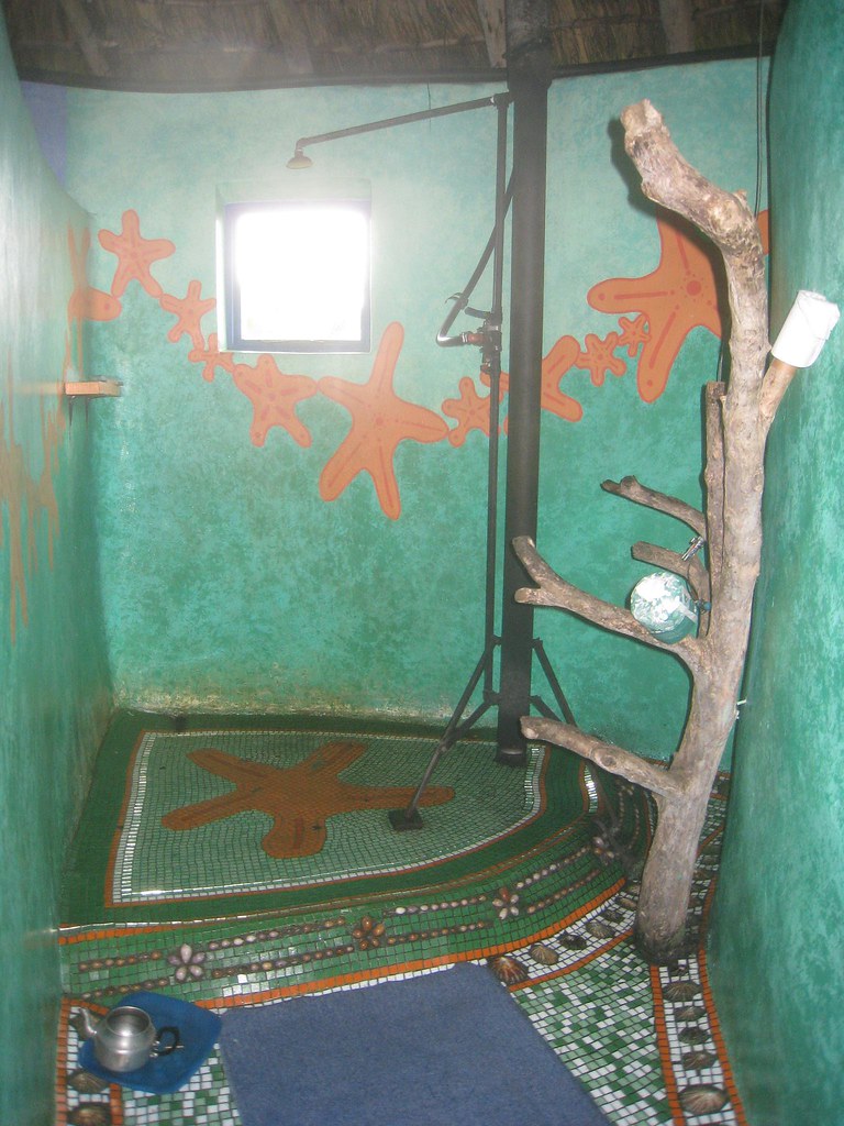 In order to provide hot water showers, despite the lack of electricity, Bulungula Lodge provides paraffin wax "rocket" showers. Pour some of the melted wax in the teapot into the base of the black shower pipe, stick a few sheets of toilet paper into the wax, and then light it like a candle wick. Once the wax catches on fire, turn on the water, and the steam will heat it up. 