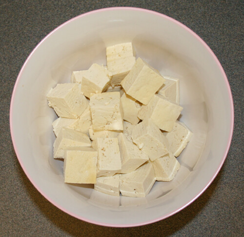 Cube tofu into about 1/2 inch pieces. Place in a small bowl and cover with 1 tablespoon of fish sauce. Set aside.