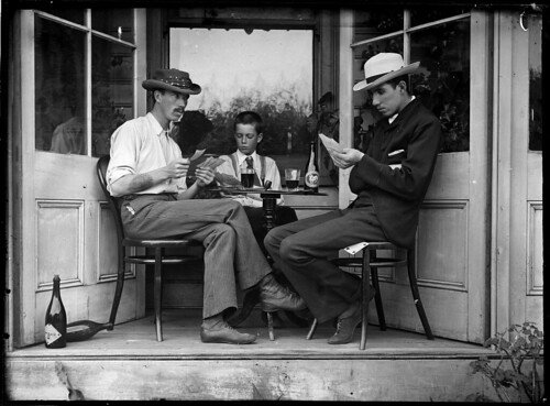 Three men playing cards in an alcove
