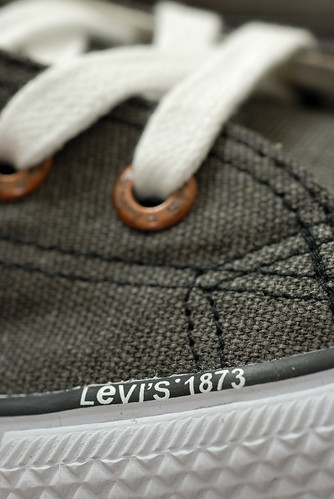 在鞋子的外側前方，鞋底和帆布的接縫處印著 levi's 1873 的字樣。