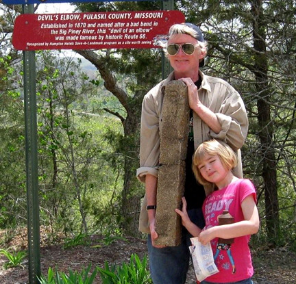 Kip Welborn, with his daughter Natalie, holding the old highway marker near Devils Elbow, Mo.