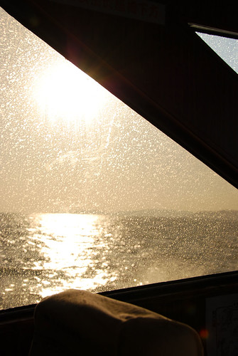 晴空萬里，陽光撒在海面和布滿浪花的窗戶上，形成特殊光影