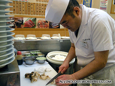 Sushi chef slicing up a fresh piece of abalone