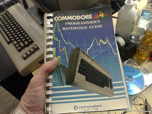 A hand holding a Commodore64 Programmer's Reference Guide