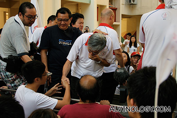 A young boy shaking Mr Chiam's hand