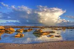 Sky clouds rocks water sand