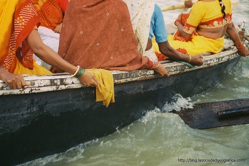 Mujeres echan ofrendas al Ganges. 