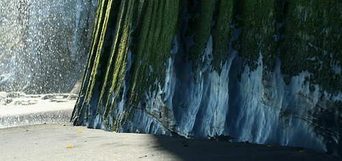 Closeup: Waterfall, cliffs, on a black sand beach