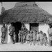 Aboriginal men and children outside hut, Hermannsburg Mission