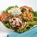 Fresh homemade tuna, chicken, and shrimp salads served on a bed of lettuce with tomatoes and garnish.