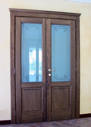 Porta interna in legno massiccio a due ante con capitello e vetri decorati