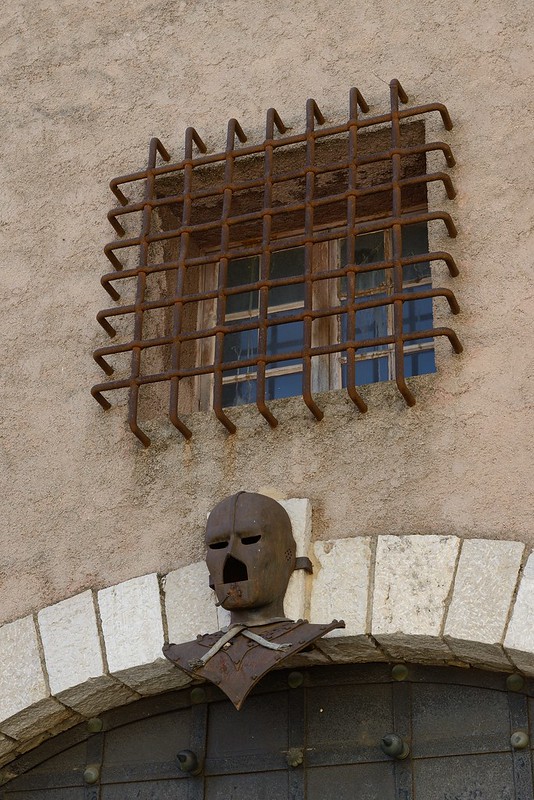 1094-20160524_Cannes-Cote d'Azur-France-metal mask and grilled window in buildings on E side of Residence de la Citadelle (Rue du Mont Chevalier)<br/>© <a href="https://flickr.com/people/25326534@N05" target="_blank" rel="nofollow">25326534@N05</a> (<a href="https://flickr.com/photo.gne?id=33105768152" target="_blank" rel="nofollow">Flickr</a>)